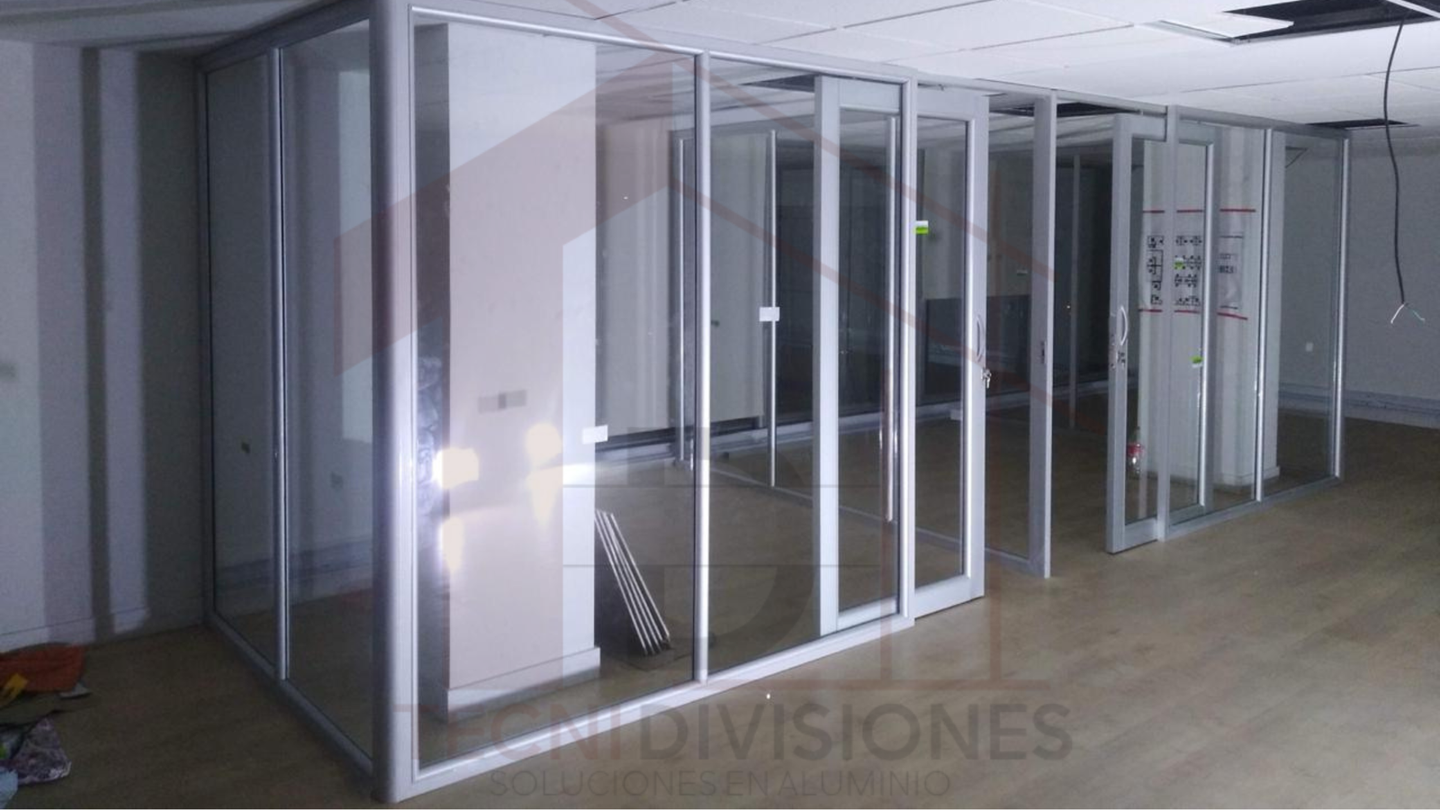 Instalación de divisiones de oficina en aluminio y vidrio con múltiples cubículos en Bogotá.