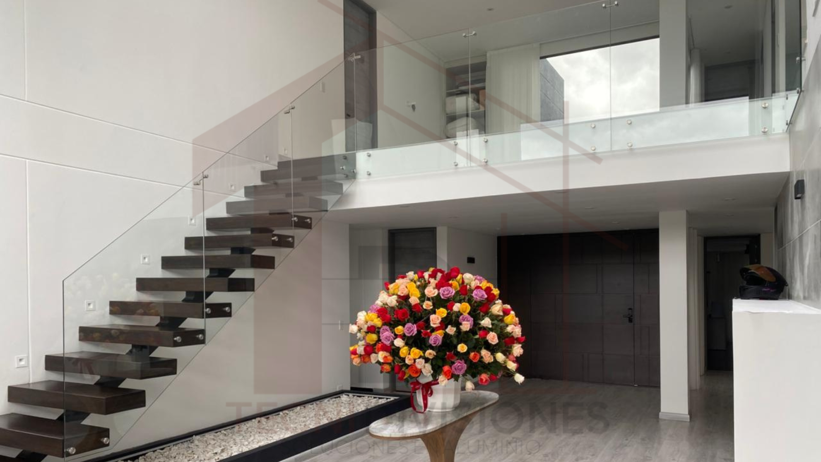 Barandal de vidrio templado para escaleras y balcón interior instalado en vivienda moderna en Bogotá.