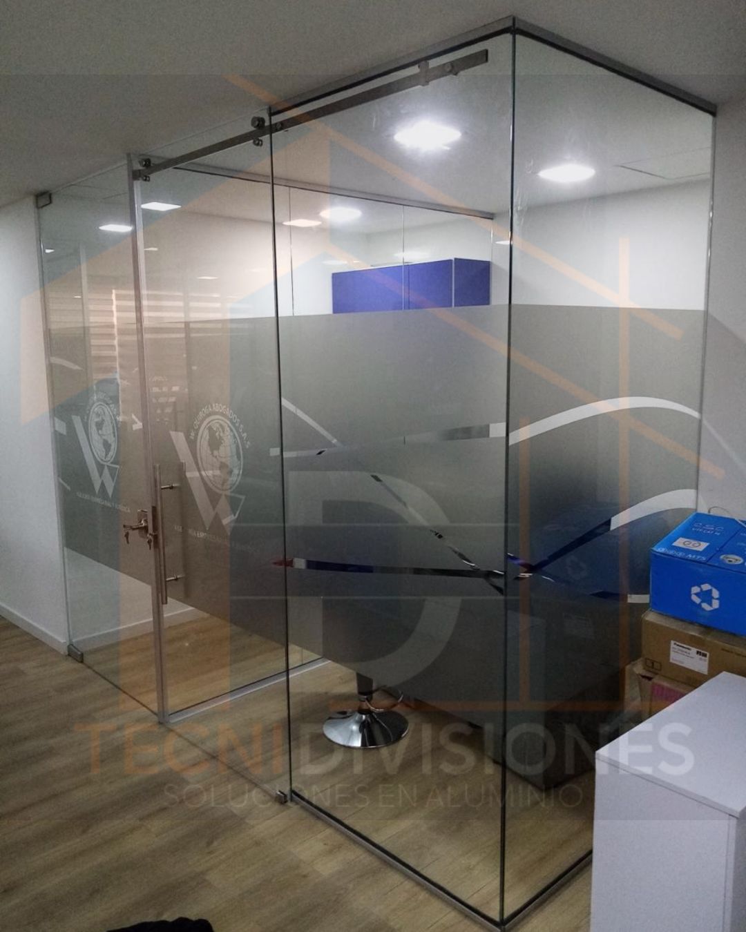 Oficina en vidrio templado con puerta corredera y vinilo esmerilado con logo empresarial