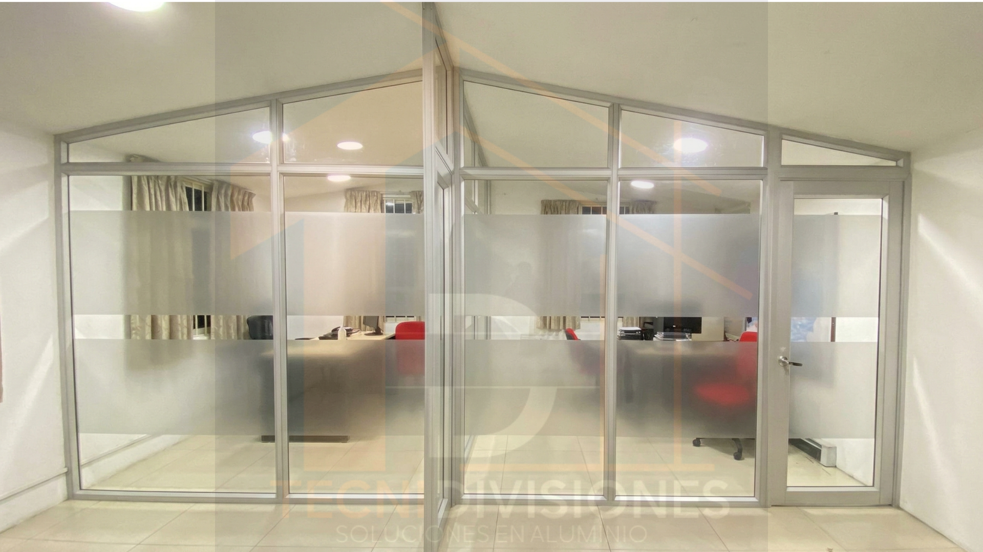 División en aluminio y vidrio esmerilado adaptada a techo en dos aguas con puerta abatible para oficina en Colombia