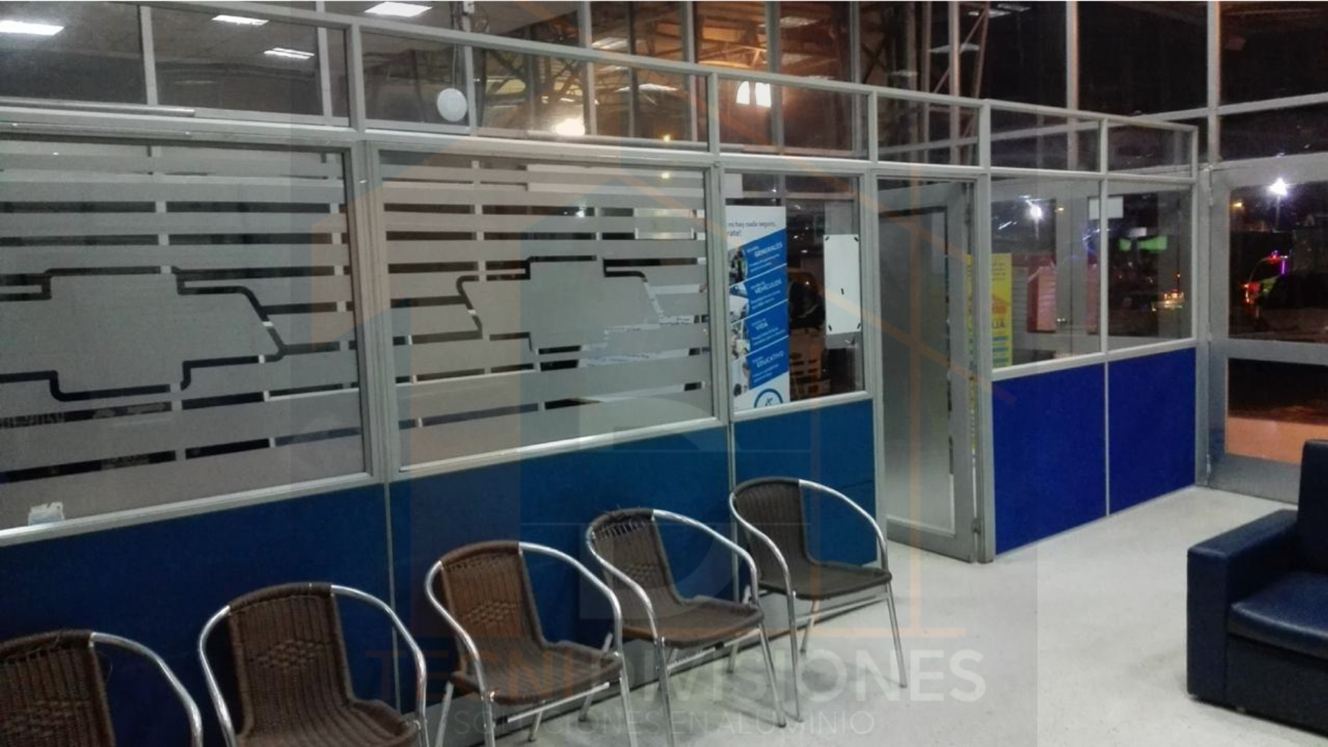 División en aluminio con vidrio esmerilado decorativo y panel inferior azul para punto de atención al cliente